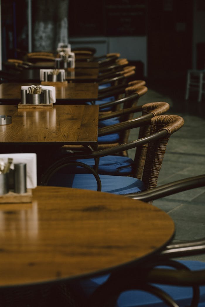 Wooden tables with blue-cushioned chairs in a cozy restaurant setting in Kaş, Antalya.